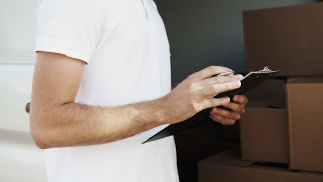 Person holding a clipboard and pen